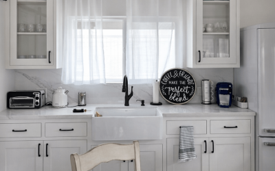 Bright, modern kitchen cabinetry with glass‑front uppers, clean white finishes, and a warm, inviting countertop layout.