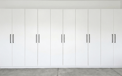 Sleek wall‑to‑wall garage storage with tall white cabinets for a clean, streamlined look.