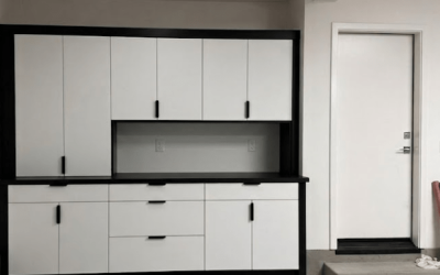 Two‑tone garage cabinetry with upper and lower storage, a durable work surface, and a clean, functional layout.
