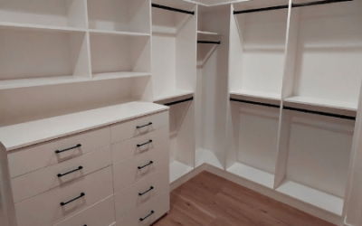 A neatly arranged shoe and accessory closet with white shelving and a clean, structured layout.