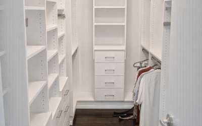 A modern walk‑in closet with full‑height shelving, drawers, and warm wood flooring for a refined storage space.